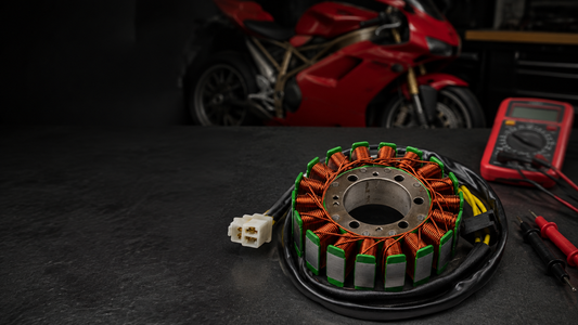 18-coil 3-wire Ducati stator beside a multimeter in a motorcycle workshop
