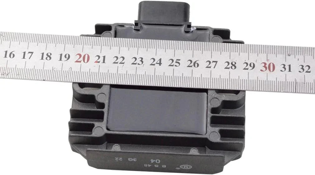 Kawasaki motorcycle regulator rectifier with a ruler showing dimensions